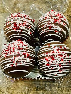 chocolate covered desserts with white and red sprinkles in a plastic container