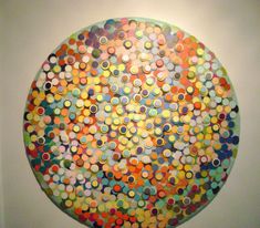 a large circular painting on the wall with circles painted all over it in different colors