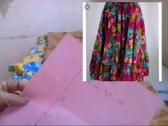 a woman is making a dress out of pink paper