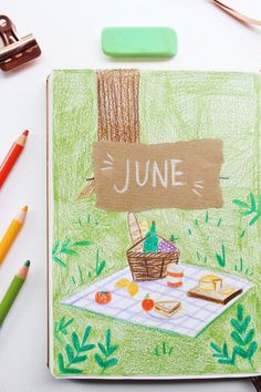 a drawing of a picnic with the word june written on it and some crayons next to it