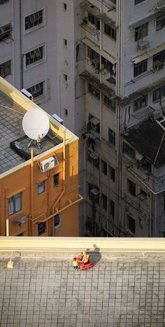 a satellite dish on top of the roof of a building in an urban area with tall buildings