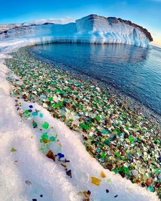 an iceberg that is floating in the water next to some glass bottles and rocks