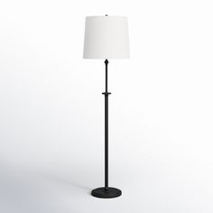 a black floor lamp with a white shade on the top and bottom part of it