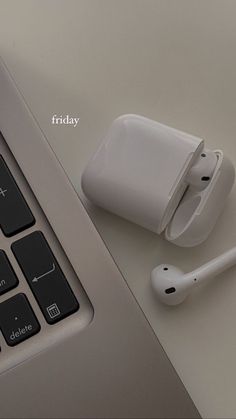 an apple airpods sitting on top of a laptop computer next to a keyboard and mouse