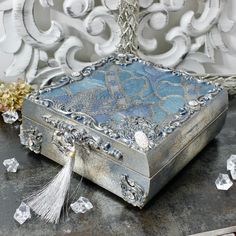 an ornate silver box sitting on top of a table next to some crystal cubes