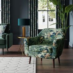 a living room with two green chairs and a white rug on the wooden flooring