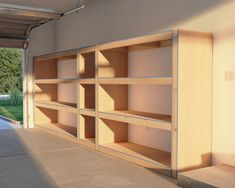 an empty bookcase in the middle of a garage with sun shining on it's windows