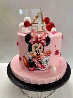 a pink birthday cake with minnie mouse on it's top and the number four