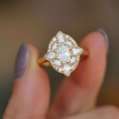 a close up of a person holding a ring with diamonds on it's fingers