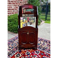 an old wooden magazine rack on top of a rug in front of a brick building