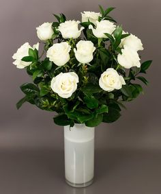 a white vase filled with lots of white flowers