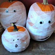 three plastic pumpkins decorated with white mesh