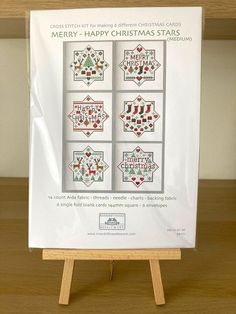 a cross - stitch christmas card on a wooden easer with four different designs in it