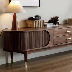 a wooden sideboard with two drawers and a lamp on top