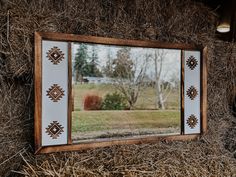 a mirror sitting on top of dry grass