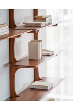 a bookshelf filled with lots of books next to a window