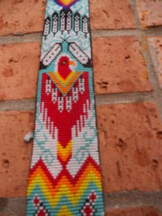 a colorful beaded tie sitting on top of a brick wall