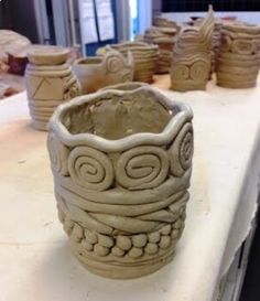 several clay cups are sitting on a table