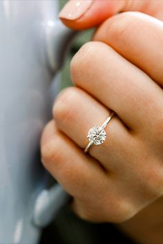 a woman's hand with a diamond ring on it