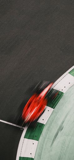 a red car driving down a race track