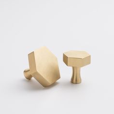 two brass knobs on white background with one in the foreground and another in the back ground