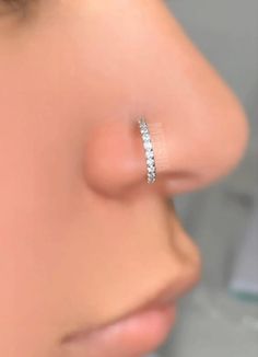 a close up of a person with a nose ring on their left side and the other end of her nose