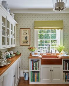 a kitchen with bookshelves, sink and window in the corner next to it