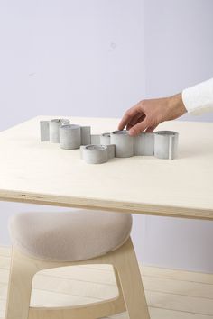 a person is reaching for some sort of object on top of a table with candles