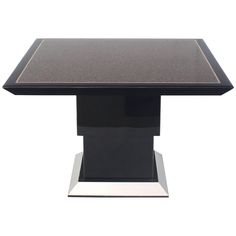 a black and silver table with a square top on an acrylic base in front of a white background