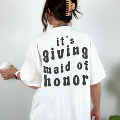 a woman wearing a white shirt that says maid of honor with stars on the back