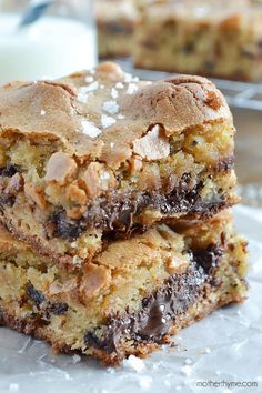 chocolate chip cookie bars stacked on top of each other next to a glass of milk