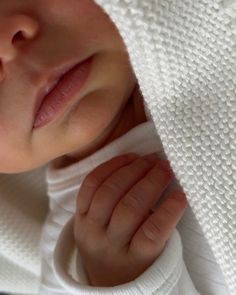 a close up of a baby under a blanket