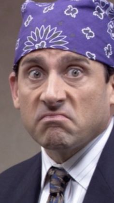 a man in a suit and tie with a bandana on his head looking surprised