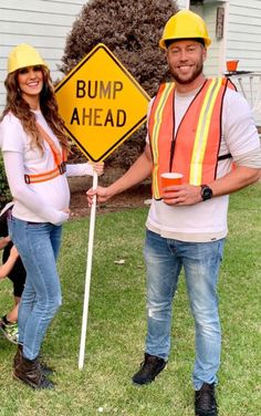 a man and woman holding a bump ahead sign