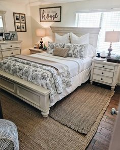 a bedroom with a bed, dressers and two lamps on either side of the bed