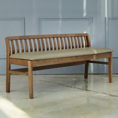 a wooden bench sitting on top of a white floor next to a blue garage door