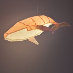 an origami fish hanging from a string in the air with its mouth open