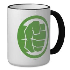 a green and white coffee mug with a fist in the middle