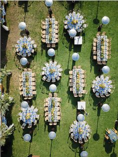 an aerial view of tables and chairs set up in the grass