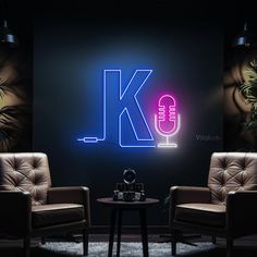 two chairs and a table in front of a wall with the letter k on it