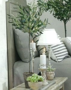 a living room filled with furniture and plants on top of a wooden table next to a couch