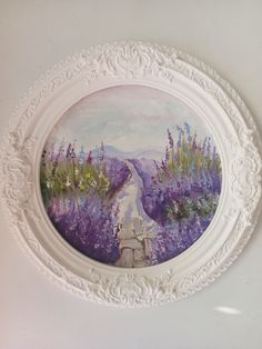 a painting hanging on the wall above a white frame with purple flowers painted on it