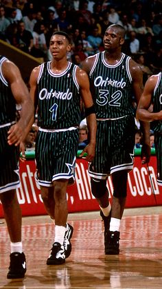 three basketball players are walking on the court