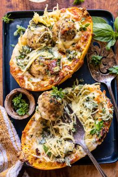 two stuffed sweet potatoes topped with meatballs and cheese on a blue serving platter