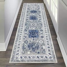 a blue and white runner rug on the floor in a hallway next to a door