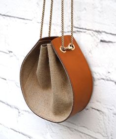 an orange purse hanging on a white brick wall