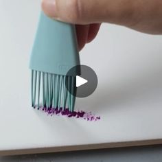 a person is holding a toothbrush with purple crumbs on the bristles