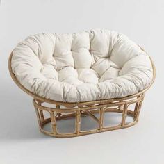 a round chair made out of bamboo with white cushions