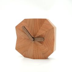 a wooden clock that is shaped like a hexagonal object with a wood handle