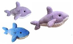 three different types of stuffed animals in the shape of fish and dolphin, one is purple